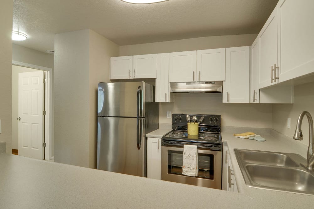 Kitchen with stainless steel appliances and white cabinets at Carriage House Apartments in Vancouver, Washington