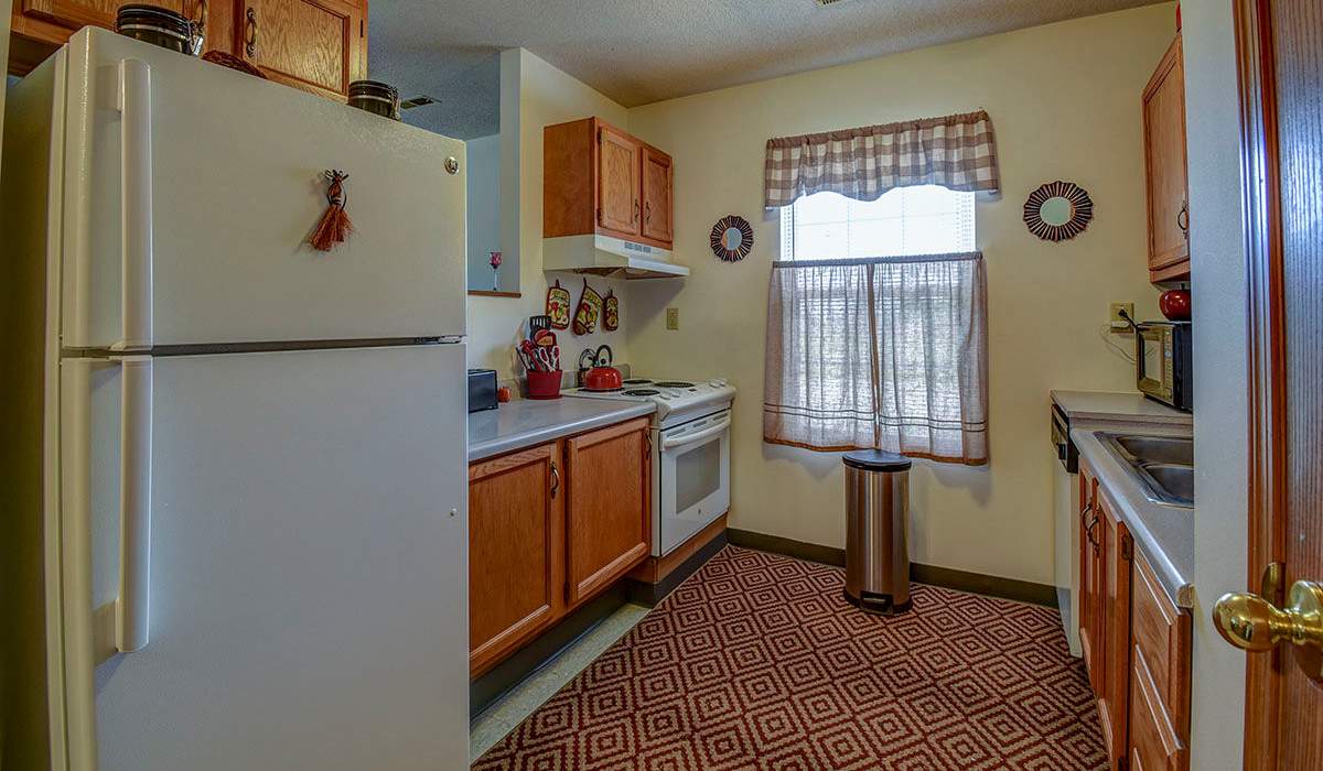 Kitchen with appliances and wooden cabinets at St. Paul Terrace in Parkersburg, West Virginia
