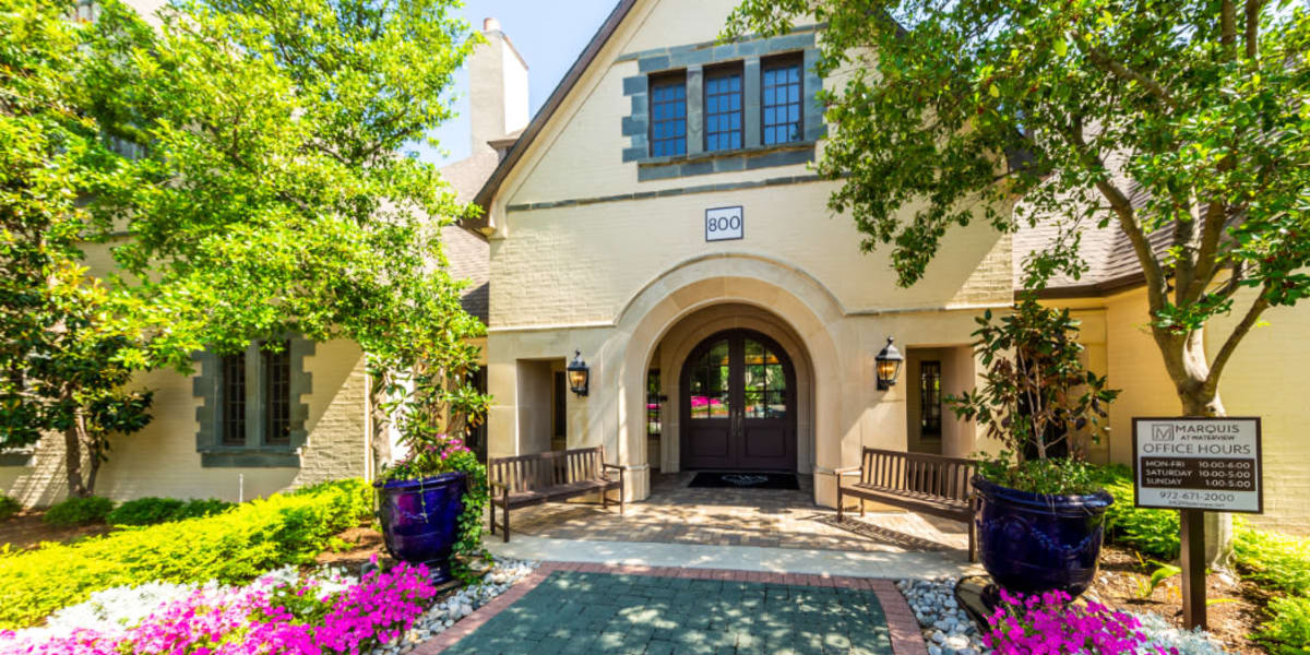 Leasing office main entrance with paved path and flowers along sides at Marquis at Waterview in Richardson, Texas