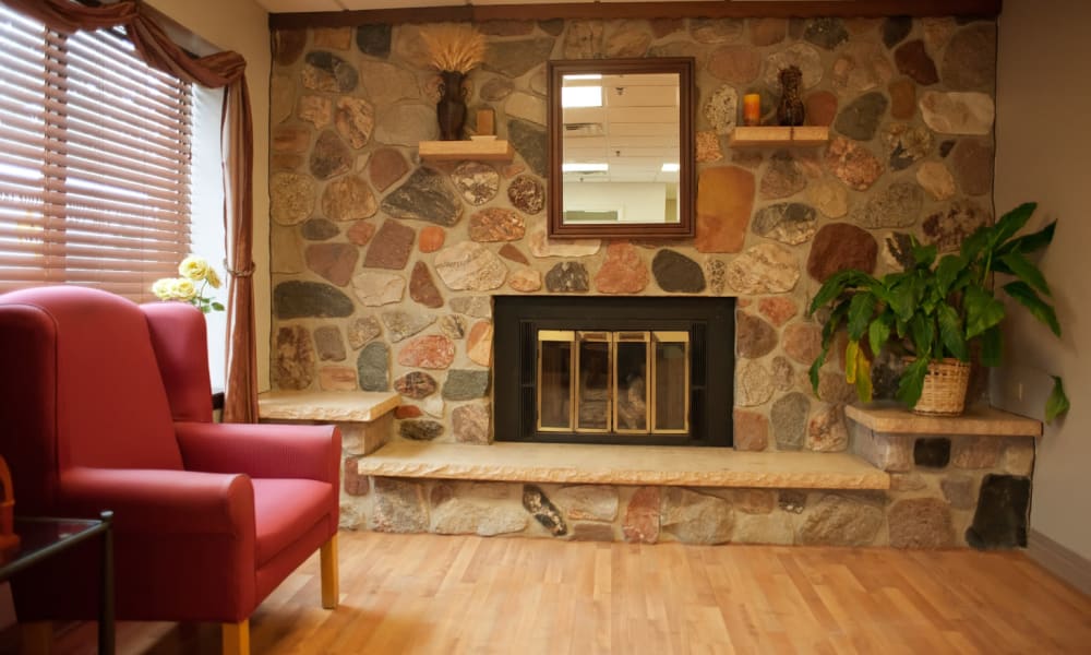 Resident common area with fireplace at Geneva Lake Manor in Lake Geneva, Wisconsin