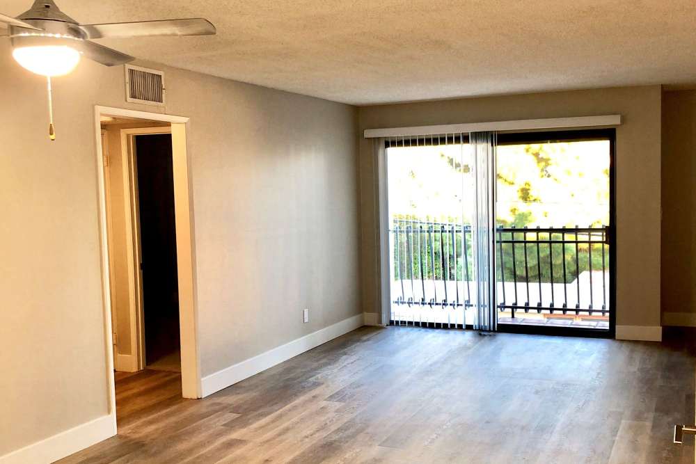Living room with wood flooring, ceiling fan, and balcony at The Indie Glendale Collection in Glendale, California