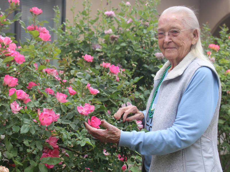 A resident looking at flowers at Desert Peaks Assisted Living and Memory Care in Las Cruces, New Mexico. 