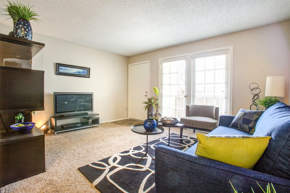 Front entrance and living room with large windows and private patio access at Verde Apartments in Tucson, Arizona