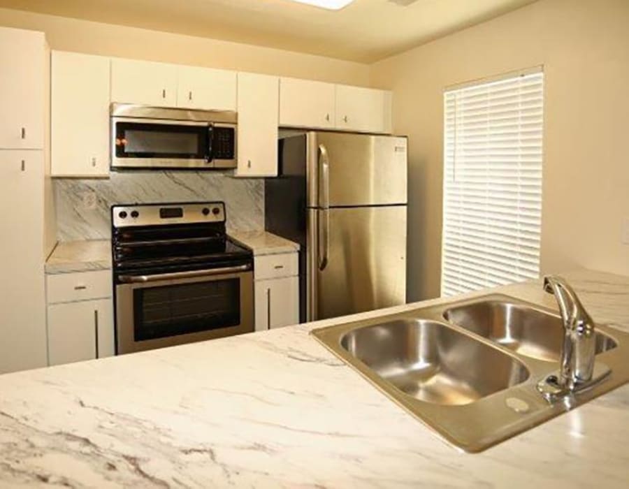 Apartment kitchen with stainless steel appliances at Acasa Tropical Ridge in Columbia, South Carolina