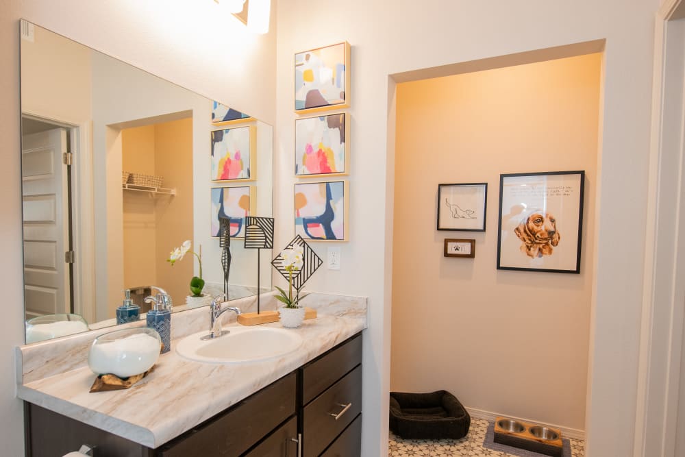 Large vanity mirror and a granite countertop in a model home's bathroom at 24Hundred Apartments in Oklahoma City, Oklahoma