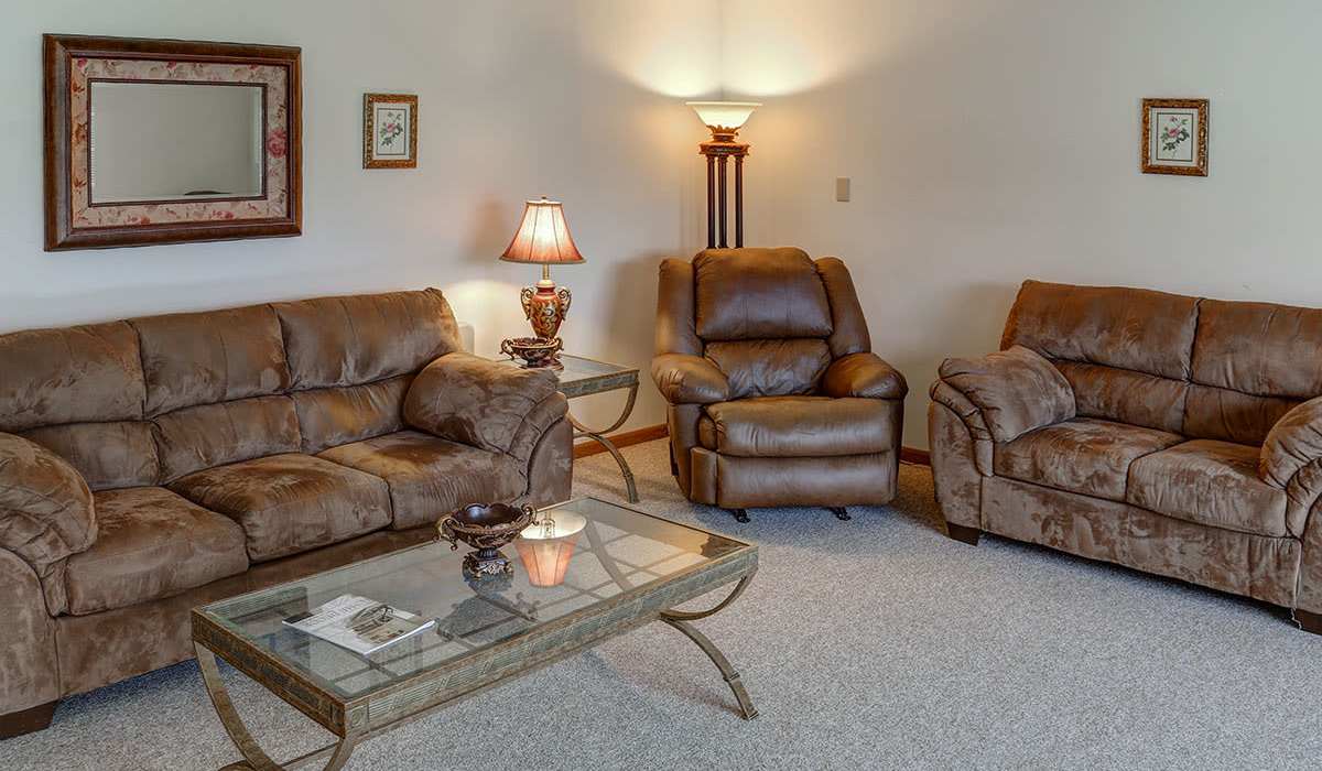 Community lounge with plush seating and glass table at Riverview Place in Ripley, Ohio