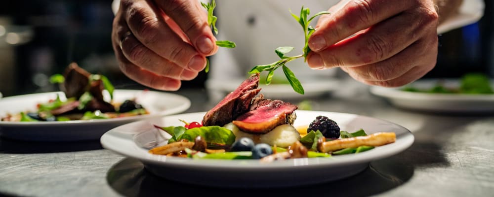 Chef putting the garnish on a complete dish at The Springs at Lake Oswego in Lake Oswego, Oregon