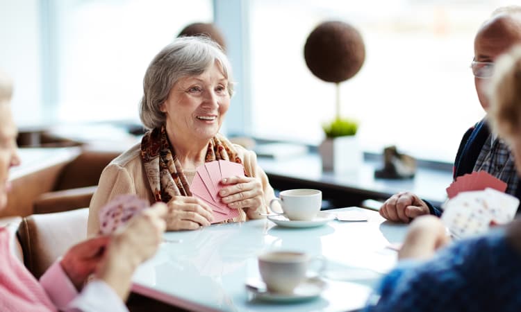 Residents playing cards and drinking tea at The Gardens at Creekside