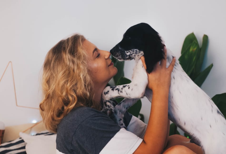 Resident giving her dog a kiss in their new home at Terra Martinez in Martinez, California