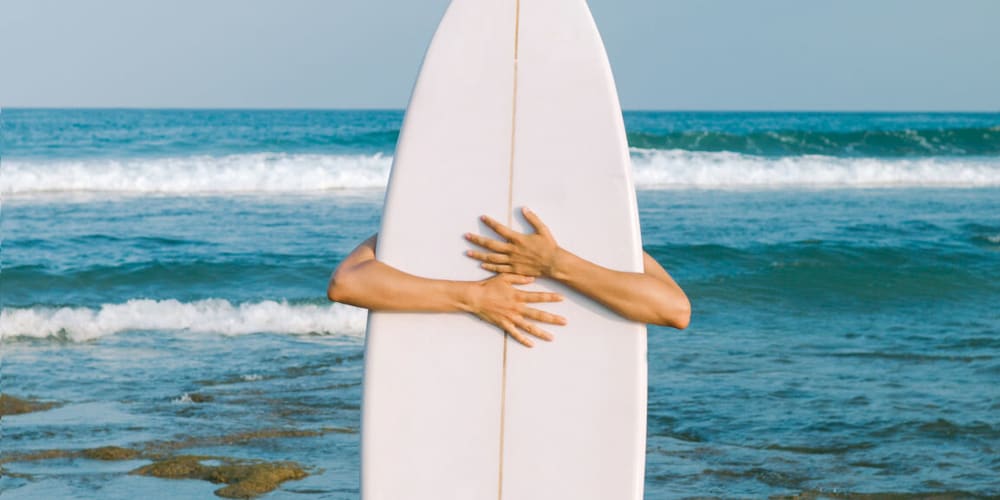 Resident holding a surfboard at Olea eTown in Jacksonville, Florida