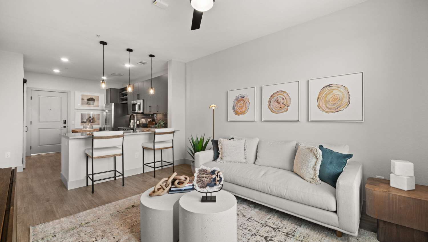 Living room with hard-wood style flooring and plenty of room for a couch and more at The Lock at Flatirons in Broomfield, Colorado