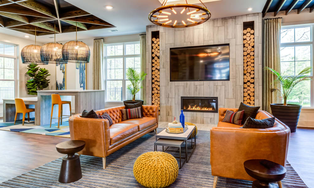 Stunning resident clubhouse lounge area with modern furniture and a cozy fireplace at Boulders Lakeside in North Chesterfield, Virginia