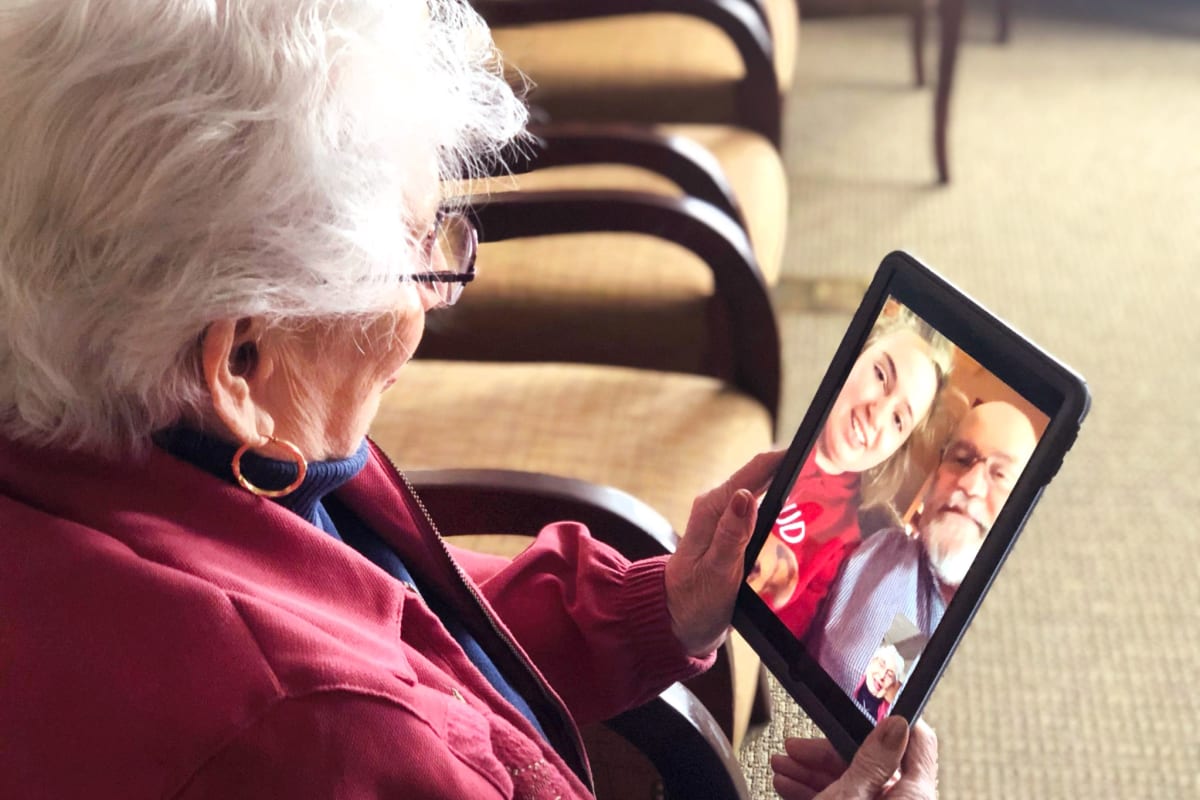 A resident using a tablet at Oxford Glen Memory Care at Carrollton in Carrollton, Texas