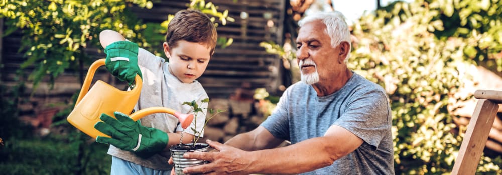 A child helping a resident water plants at Stoney Brook