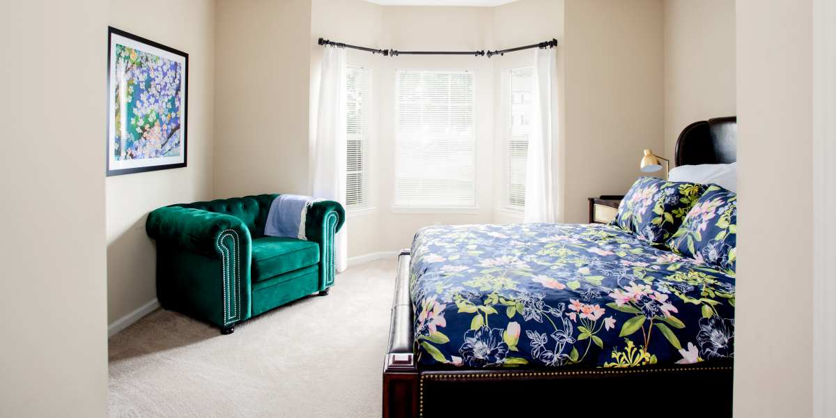 A cozy bedroom featuring a comfortable couch and bed at Madison Park in Madison, Alabama