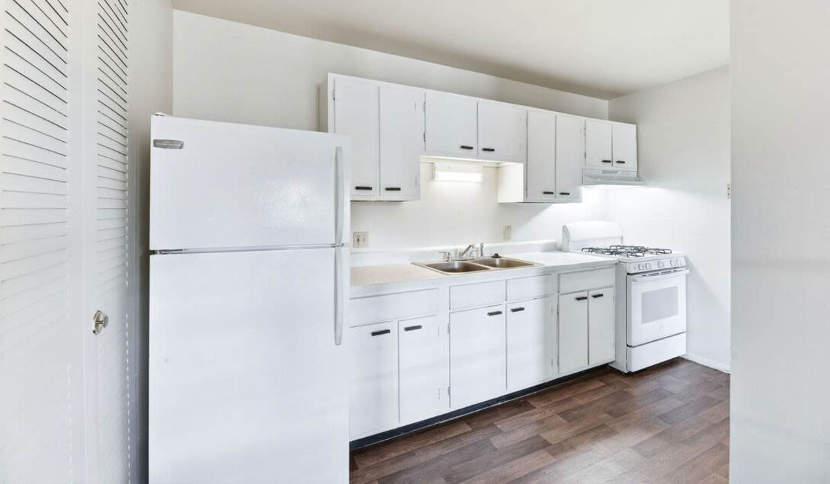 Modern kitchen with sleek white cabinetry and ample natural light at The Reserve at Pin Oak Manor Apartments in Mishawaka, Indiana.