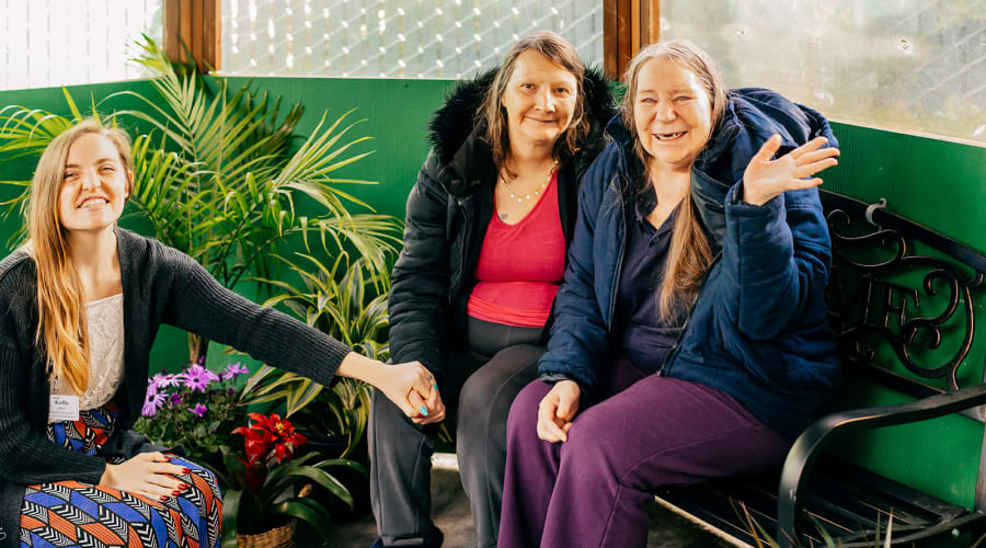 Residents and caregiver smiling for the camera at Cascade Park Gardens Memory Care in Tacoma, Washington