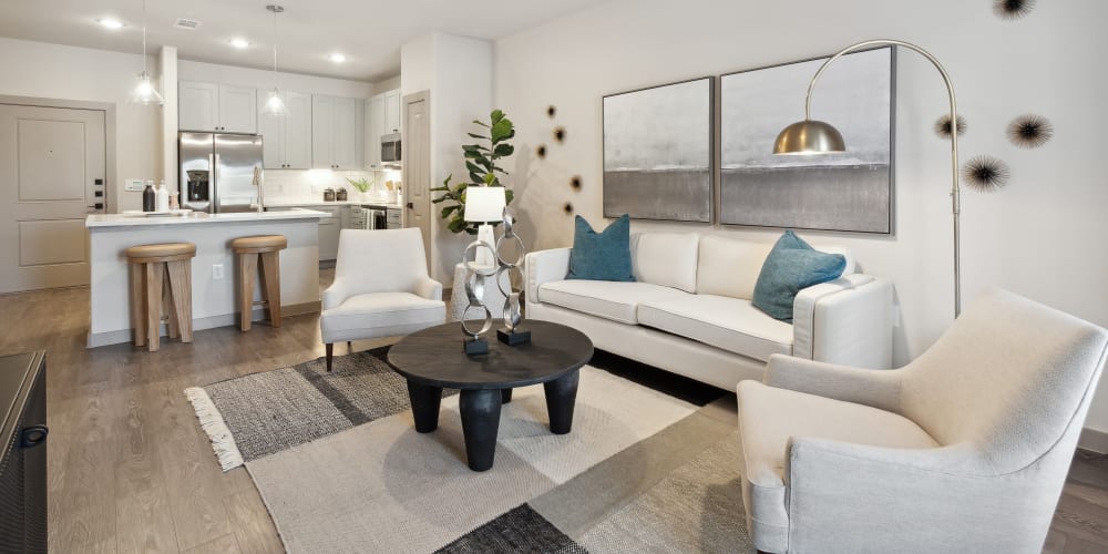 Spacious living room and kitchen with breakfast bar in a beautiful model apartment at Radius Wolf Ranch in Georgetown, Texas