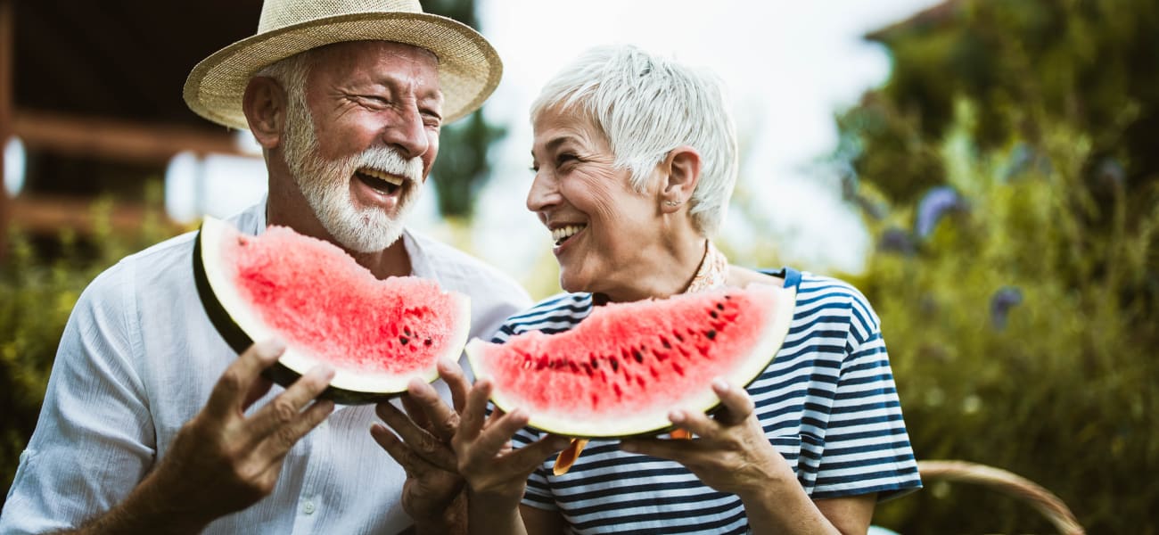 Residents embrace enjoying sliced watermelon at a Truewood by Merrill location