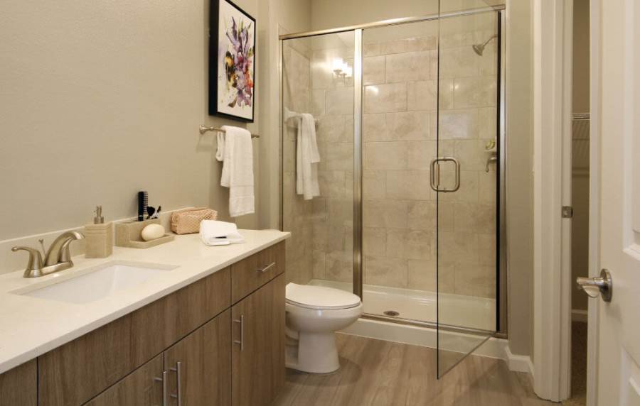 Modern bathroom with sleek shower, stylish tiles, and spacious vanity at Messina Luxury Apartments in New Smyrna Beach, Florida
