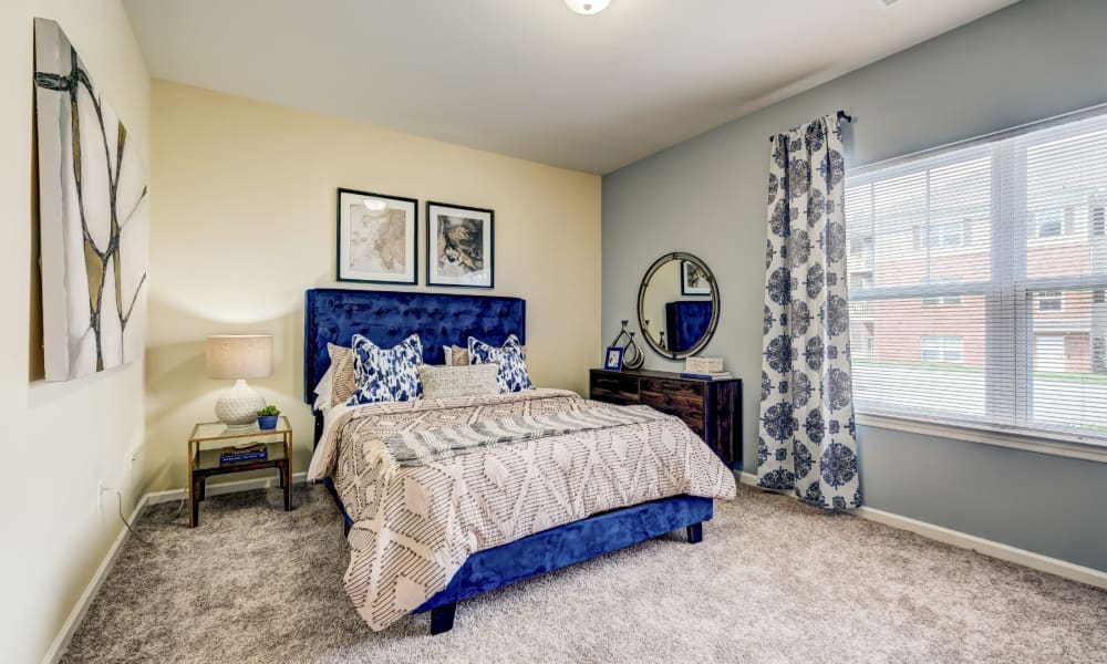 Model bedroom with plush carpeting and an accent wall at Torrente Apartment Homes in Upper St Clair, Pennsylvania