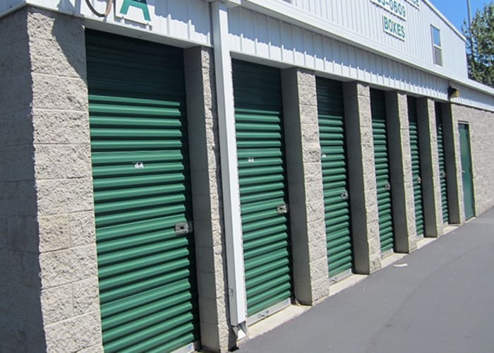 Outdoor storage units with green doors and wide driveways at A Storage Place in Lompoc, California