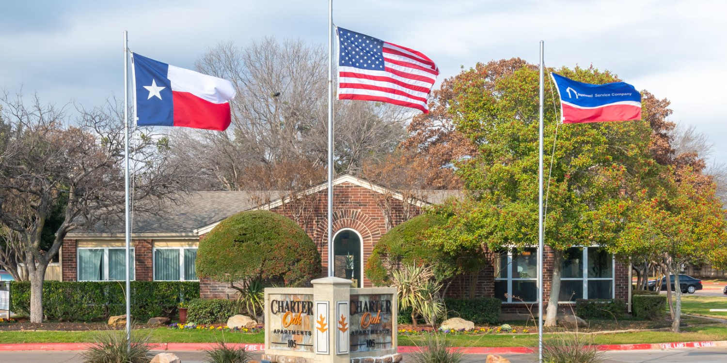 Charming apartment community with lush landscaping at Charter Oak in Euless, Texas.