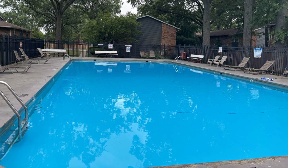 Sparkling water pool surrounded by lush landscaping at The Reserve at Pin Oak Manor Apartments in Mishawaka, Indiana.