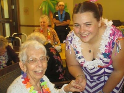 Happy volunteer with senior enjoying activities at Eastern Star Masonic Retirement Campus in Denver, CO