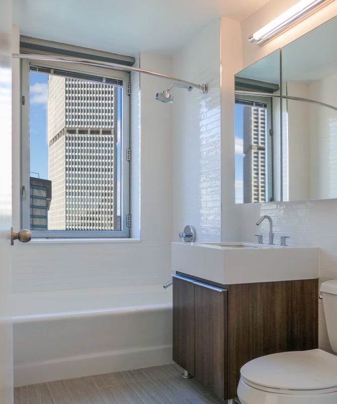 A modern bathroom with a large vanity mirror at The Metropolis in New York, New York