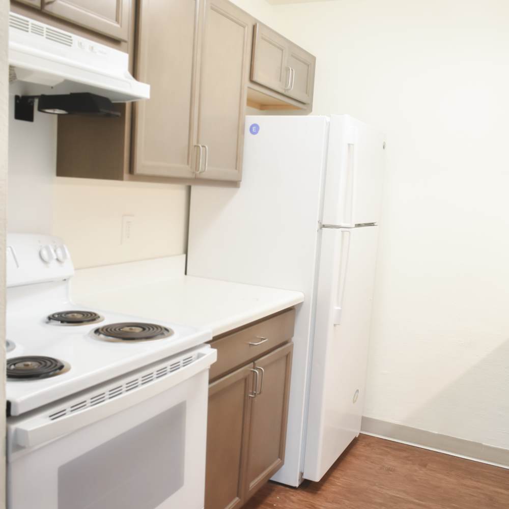 Modern kitchen with wooden cabinetry and appliances at Clairewood Apartments in Saint Clair, Michigan