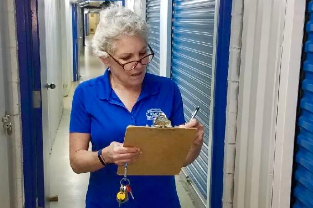 woman writing on clipboard in storage facility