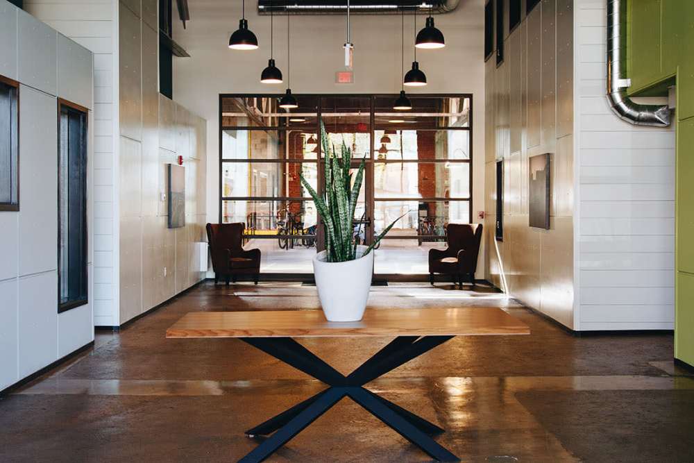 Modern lobby with stylish seating and plants at Courtyard Lofts at Scott’s Addition in Richmond, Virginia