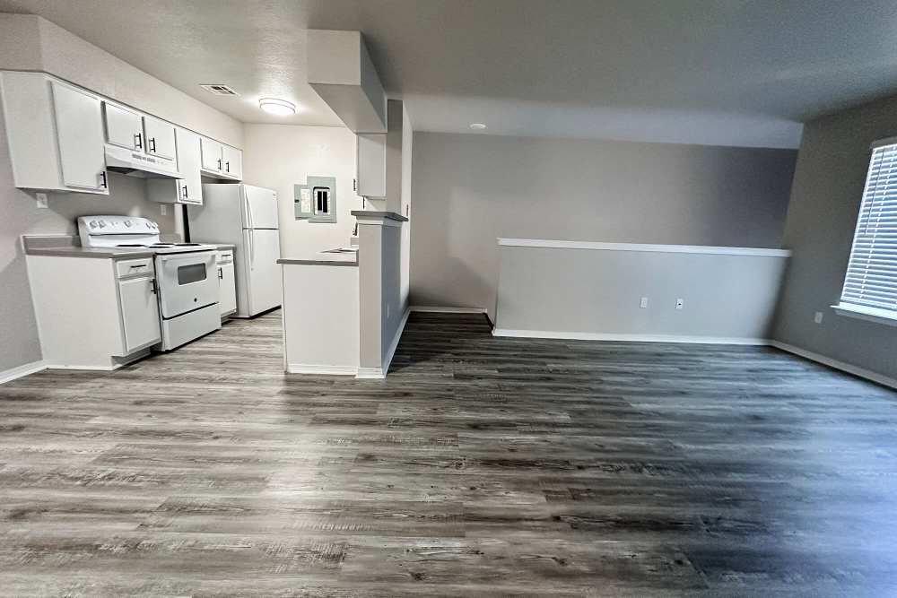 Living area with wood-style flooring at The Gardens At Pryor Creek in Pryor, Oklahoma