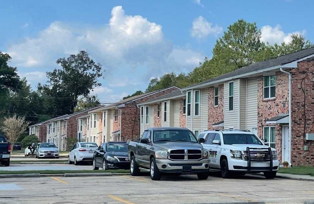 Property exterior view with cars parked at Creekwood Townhomes in Hammond, Louisiana