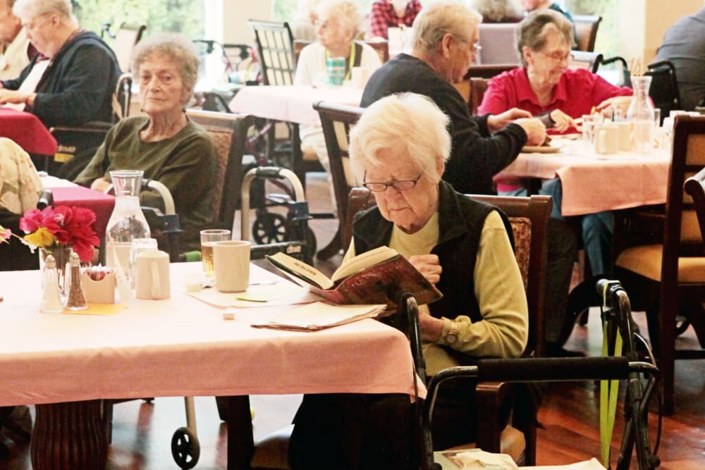 Resident reading in dining room at Heron Pointe Senior Living in Monmouth, Oregon