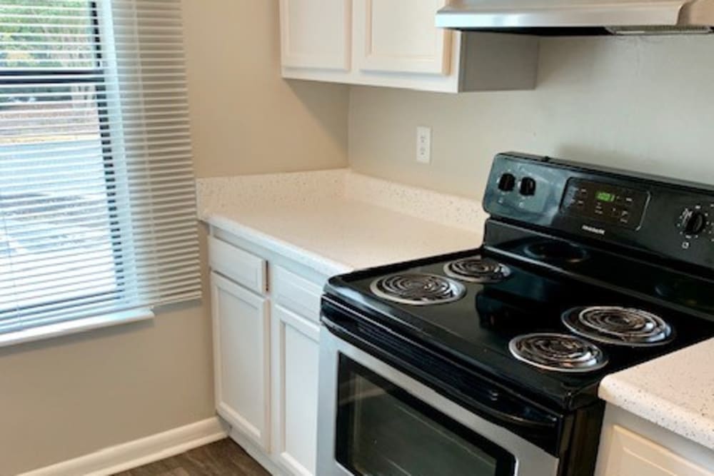 An apartment kitchen with a bright window at Amber Oaks in Durham, North Carolina