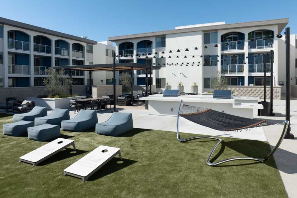 Luxury hammock on green grass with lounge chairs at Dolphin Marina Apartments in Marina Del Rey, California