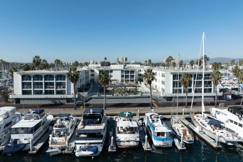 Luxury boats docked in front of a building at Dolphin Marina Apartments in Marina Del Rey, California