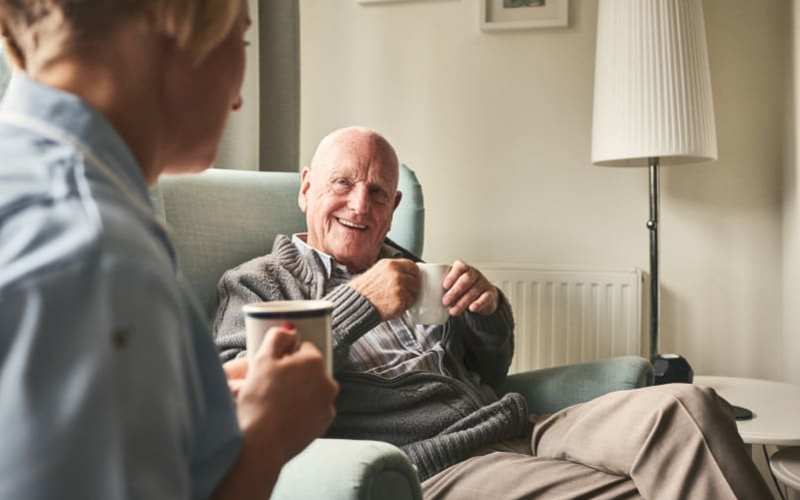 Resident having coffee with a caregiver at Grand Villa of Port Charlotte in Port Charlotte, Florida