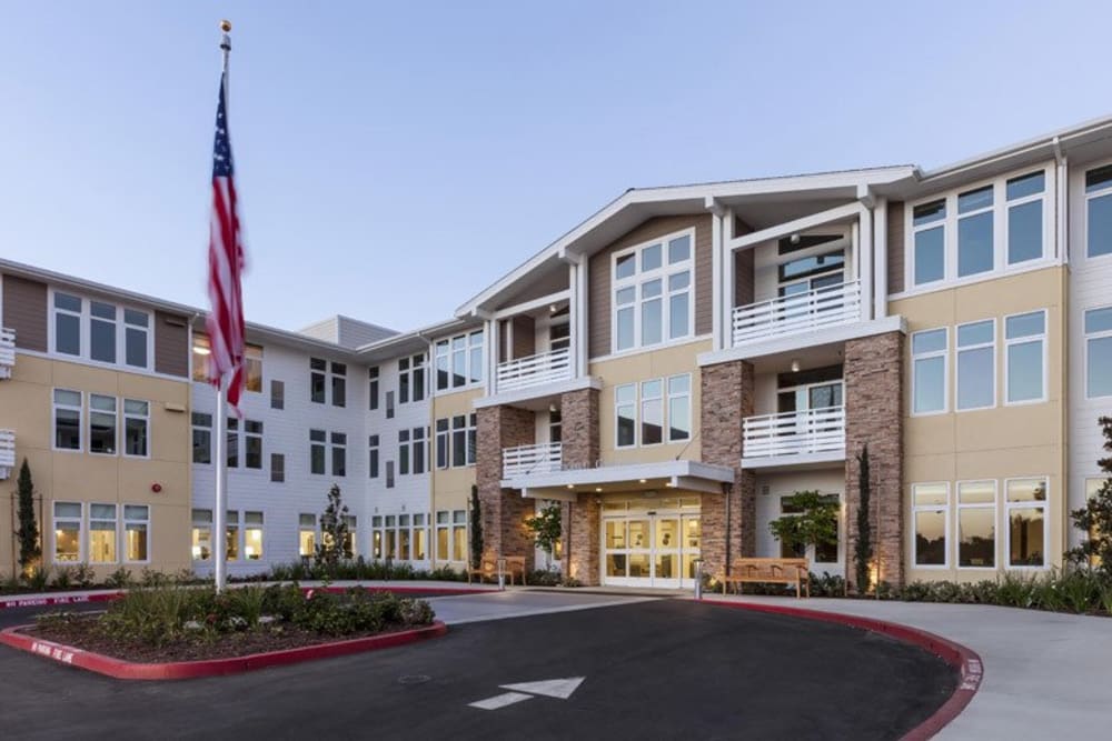 Exterior of main building with a flag at Merrill Gardens at Huntington Beach in Huntington Beach, California. 