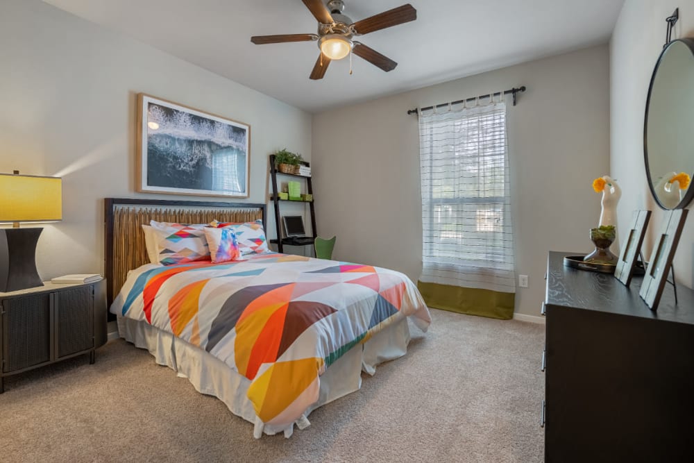 Carpeted bedroom with window and ceiling fan at Marquis at Sugar Land in Sugar Land, Texas