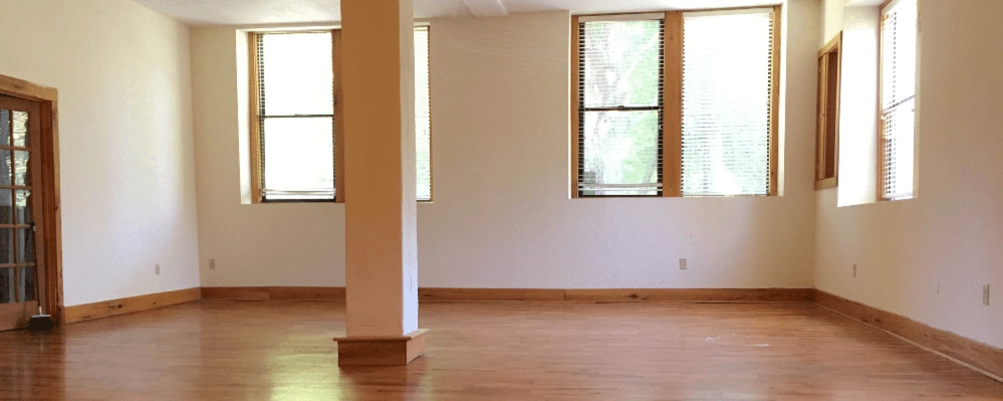 Wood flooring and large windows in an apartment living room at Kenilworth Inn in Asheville, North Carolina