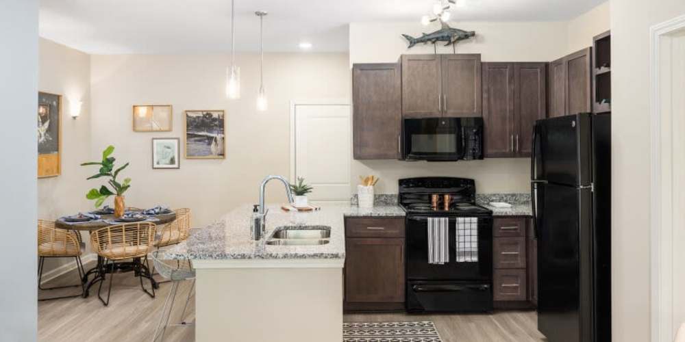 Fully equipped kitchen with granite countertops stainless-steel appliances like a refrigerator, stove, and drawer microwave at Palmetto Exchange in Ladson, South Carolina