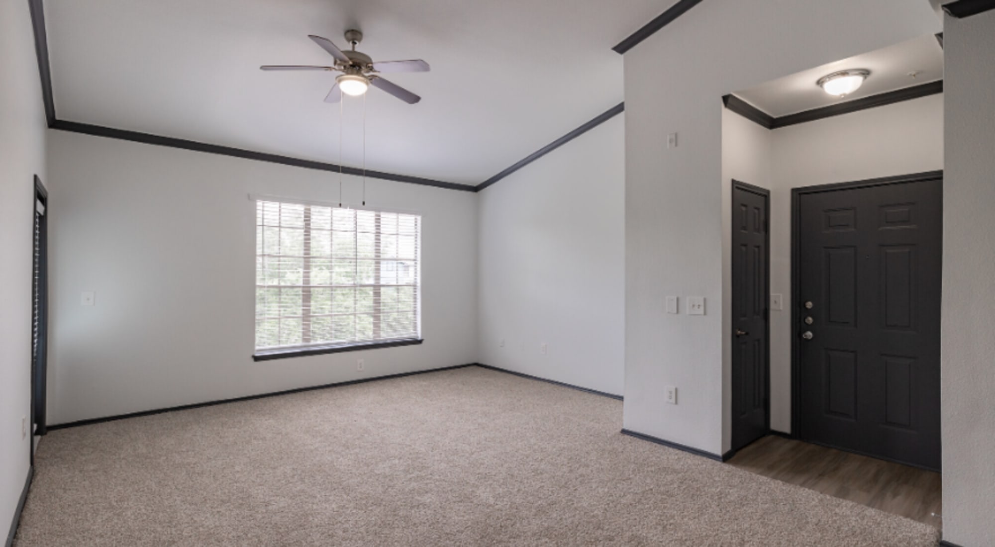 Bright living room with ceiling fan at at Legacy at Cypress in Cypress, Texas