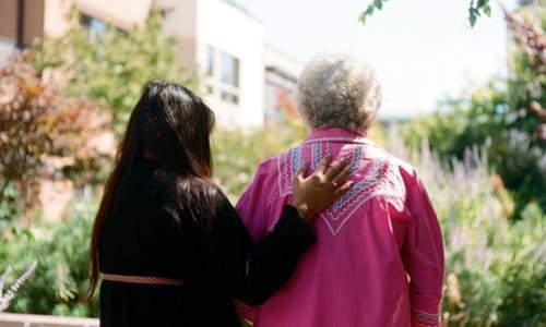 A staff member helping a resident walk at Merrill Gardens.