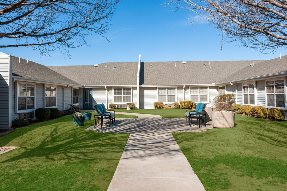 Courtyard with landscaping and patio furniture at Cimarron Place in Midland, Texas