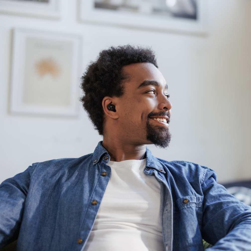 Resident relaxing in sofa at Wallace Terrace Apartments in Charlotte, North Carolina