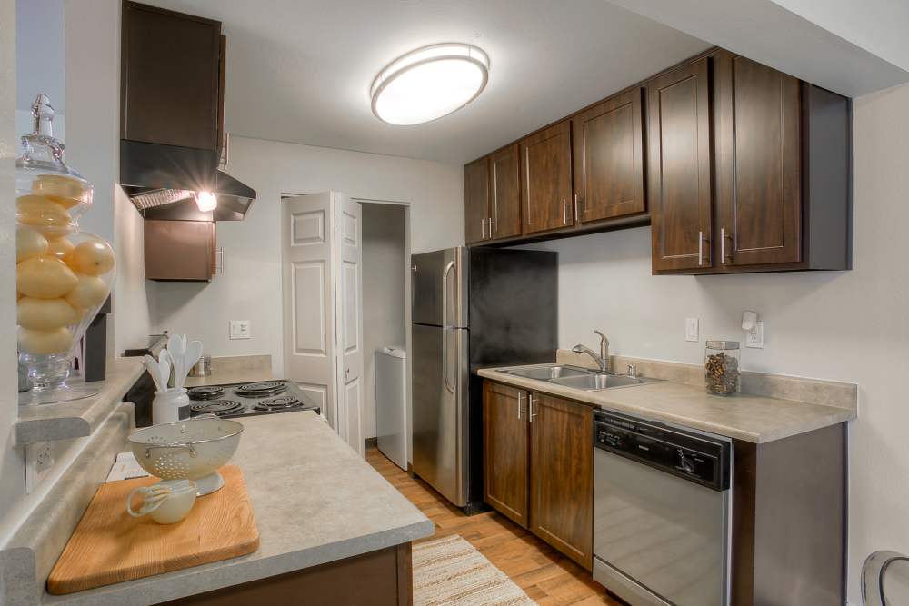 Renovated kitchen with brown cabinets  at Newport Crossing Apartments in Newcastle, Washington
