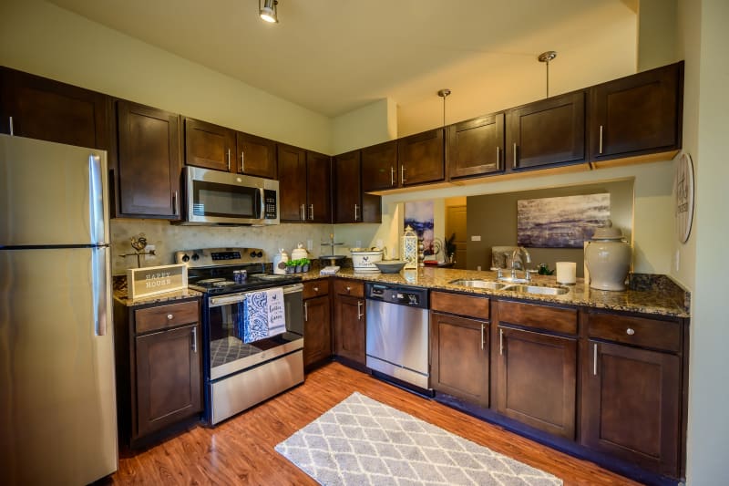 Dark wood cabinetry in model kitchen at Pecan Springs Apartments in San Antonio, Texas
